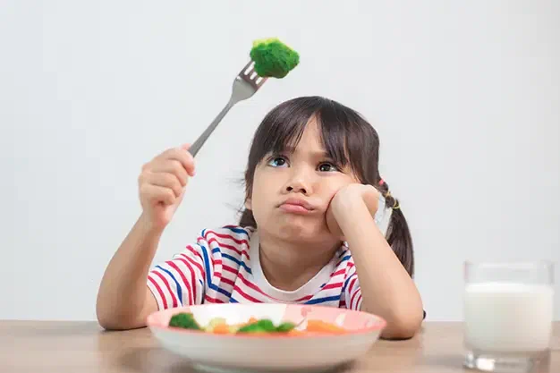 Pediatric occupational therapist working with a child on food exploration and texture acceptance at Root Pediatrics in Bozeman, Montana