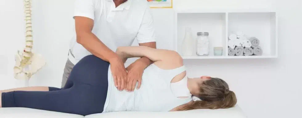 Physical therapist performing low-back joint mobilization and manual therapy at Root Therapy and Wellness in Bozeman, Montana